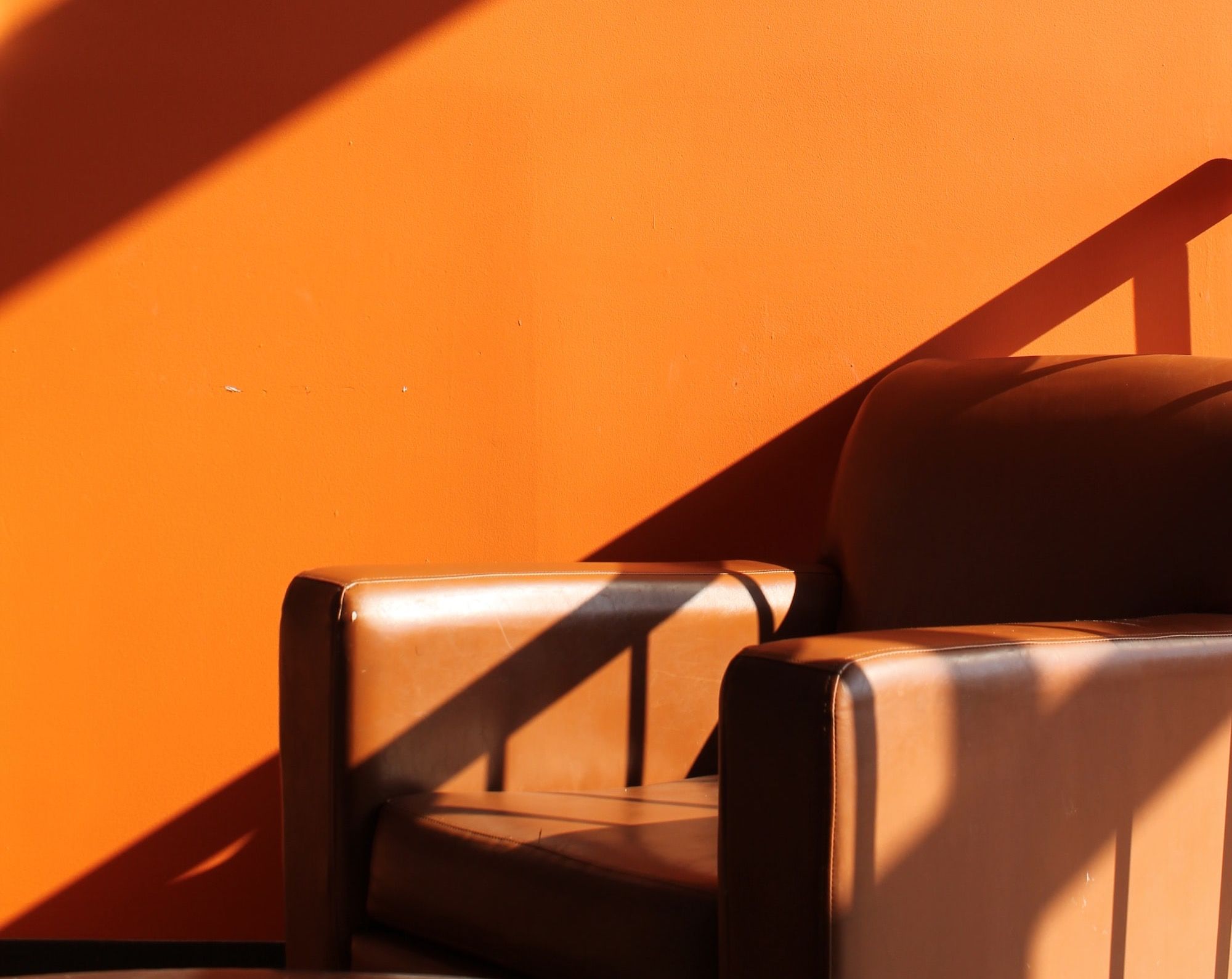 a chair sitting in front of an orange wall